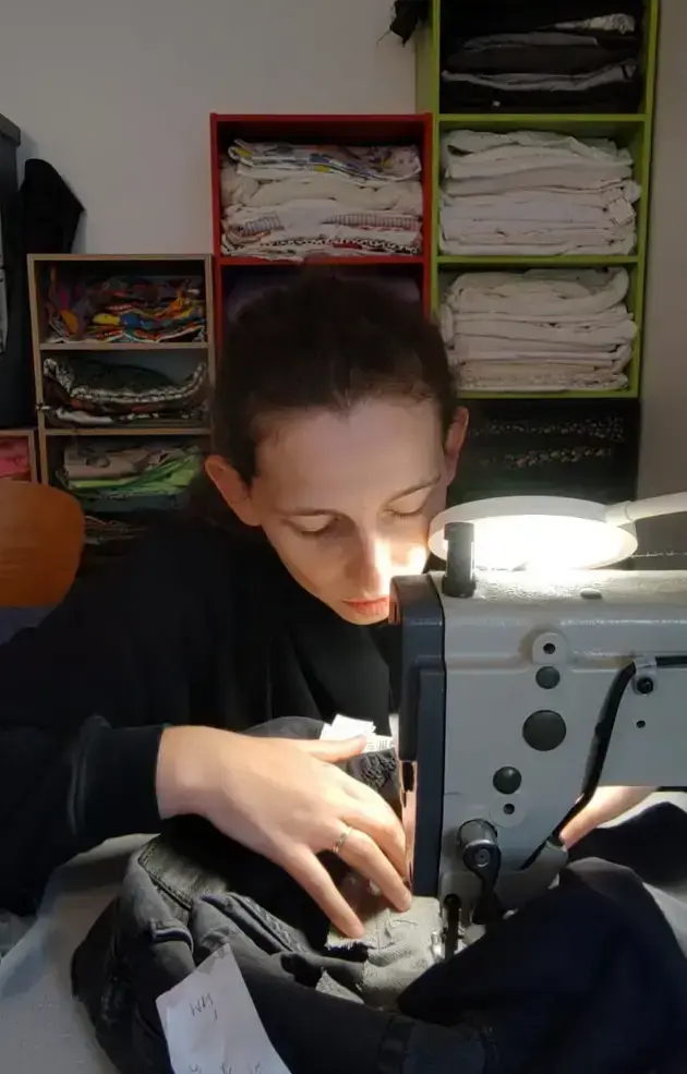 Marie, la couturière, derrière sa machine à coudre